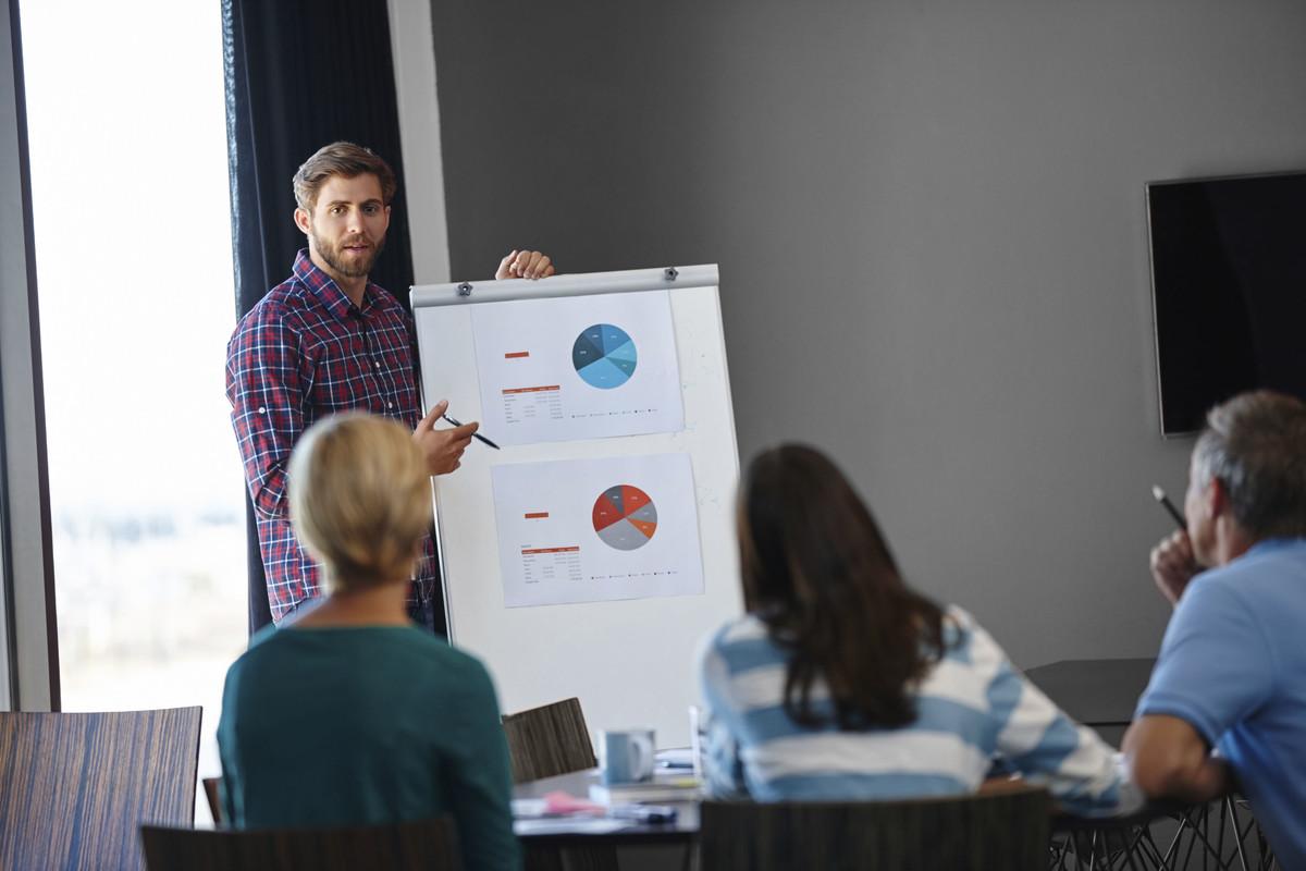 Man showing charts on whiteboard