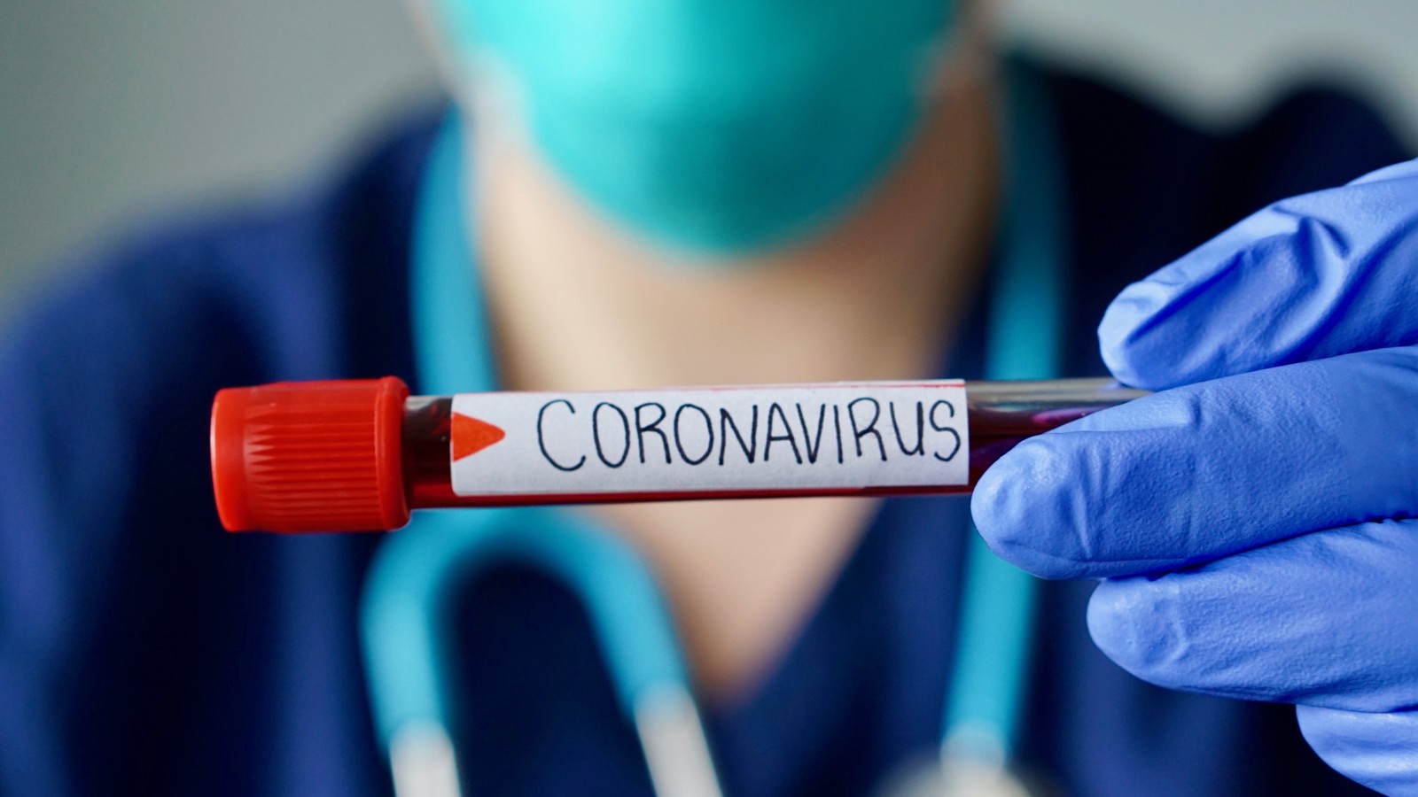 Nurse wearing respirator mask holding a positive blood test result for the new rapidly spreading Coronavirus, originating in Wuhan, China