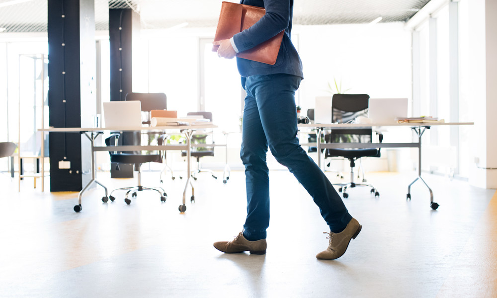 Unrecognizable businessman walking in an office.